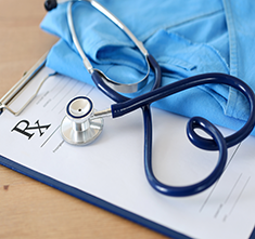 . Image-Blue scrub and stethoscope on prescription order. Click tile image to view